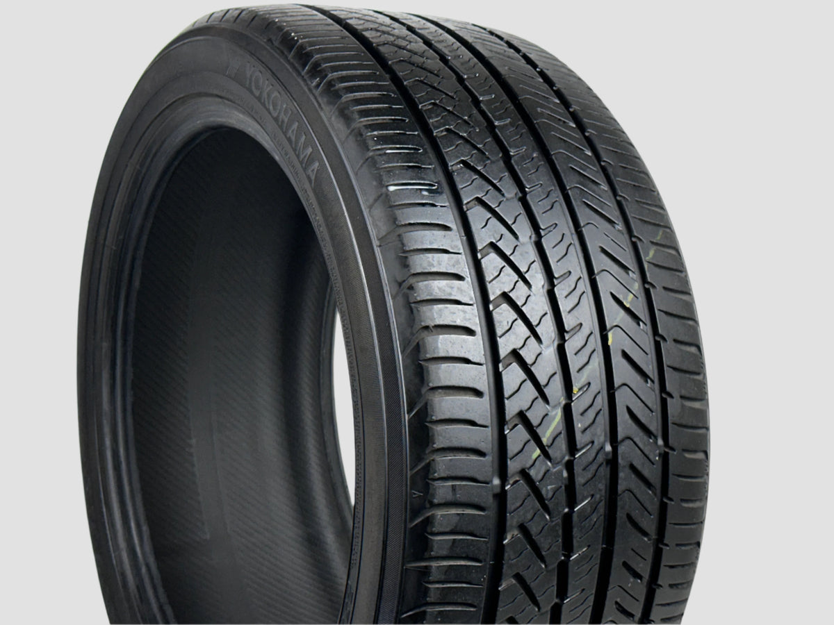 Close-up of a car tire with tread pattern on a white background